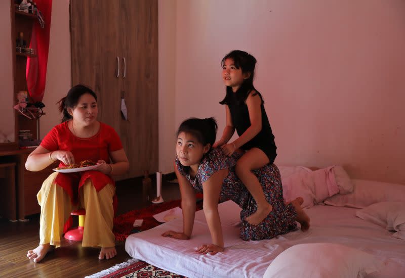 Licypriya Kangujam plays with her sister Irina Kangujam as their mother Bidyarani Devi Kangujam Ongbi looks on inside their house in Noida