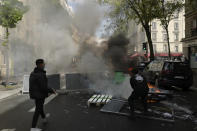 Youths stand by a barricade during a banned protest in support of Palestinians in the Gaza Strip, in Paris, Saturday, May, 15, 2021. Marches in support of Palestinians in the Gaza Strip were being held Saturday in a dozen French cities, but the focus was on Paris, where riot police got ready as organizers said they would defy a ban on the protest. (AP Photo/Rafael Yaghbozadeh)