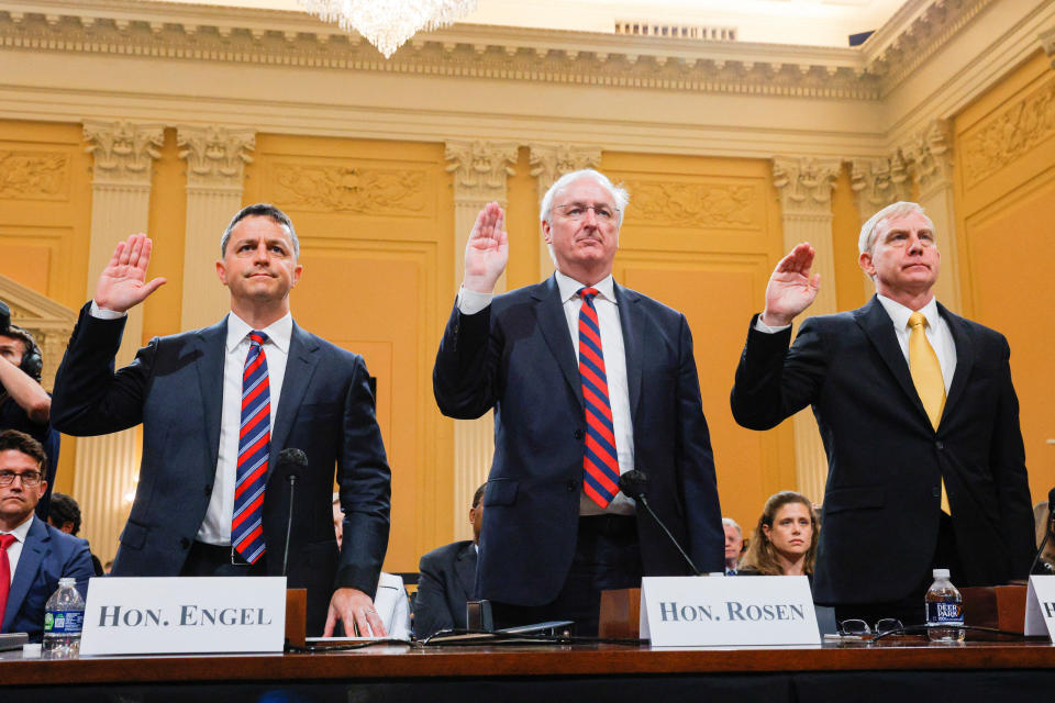 All three men raise their right hands.