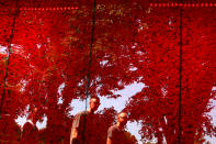 <p>People are seen reflected on a temporary memorial made of over 600,000 poppies ahead of Memorial Day at the National Mall in Washington, May 25, 2018. (Photo: Carlos Barria/Reuters) </p>