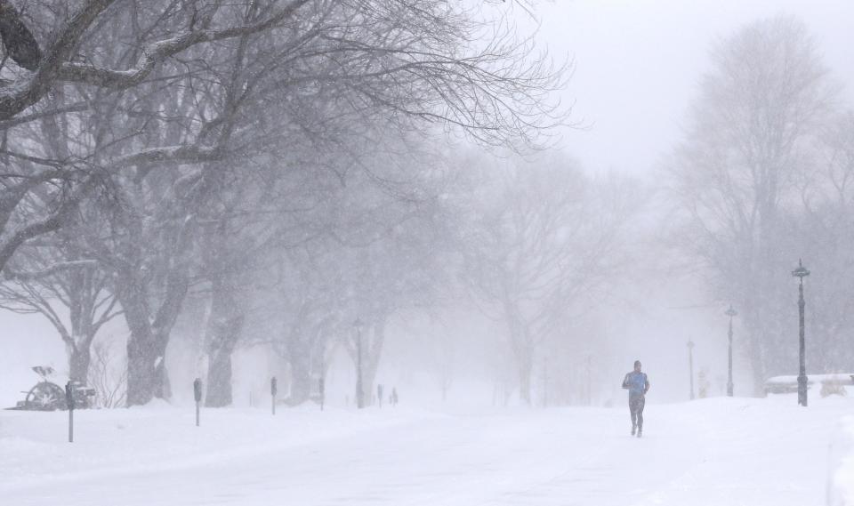 A man jogs in the street during a snowstorm in Quebec City, December 15, 2013. Between 15 and 30cm of snow are expected to fall on the different regions of eastern Canada today, according to Environment Canada. REUTERS/Mathieu Belanger (CANADA - Tags: ENVIRONMENT SOCIETY)