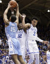 Duke's Javin DeLaurier (12) and Tre Jones (3) guard North Carolina's Garrison Brooks (15) during the first half of an NCAA college basketball game in Durham, N.C., Wednesday, Feb. 20, 2019. (AP Photo/Gerry Broome)