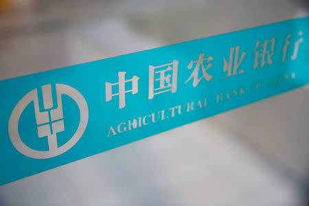 The logo of Agricultural Bank of China is seen on a glass door, in Beijing, China, August 26, 2016. REUTERS/Thomas Peter/File Photo