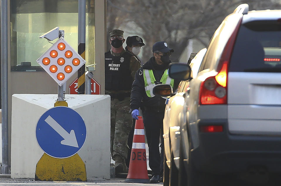 In this Thursday, Feb. 20, 2020, photo, a U.S. military policeman and South Korean security persons U.S. Army base Camp Walker, in Daegu, South Korea. The U.S. and South Korean militaries, used to being on guard for threats from North Korea, face a new and formidable enemy that could hurt battle readiness: a virus spreading around the world that has infected more than 1,200 people in South Korea. (Kim Hyun-tae/Yonhap via AP)