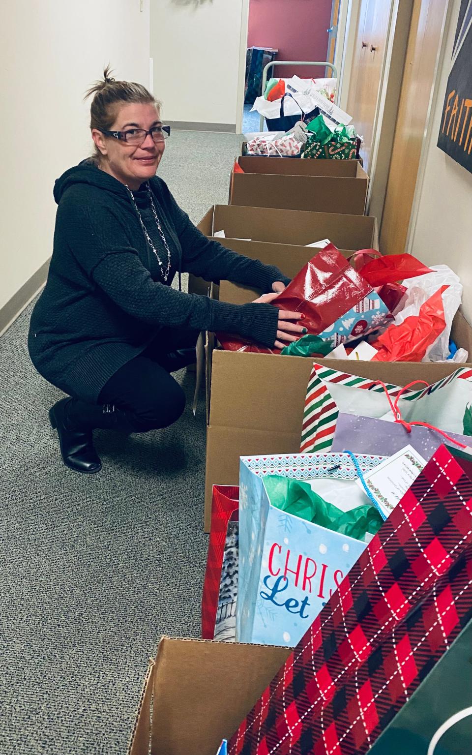 Larese Isaacson, a former staff member, looks over boxes of gifts that were given to participants in the Faith in Action program.