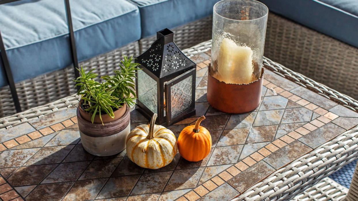 candle lantern and pumpkins on outdoor table