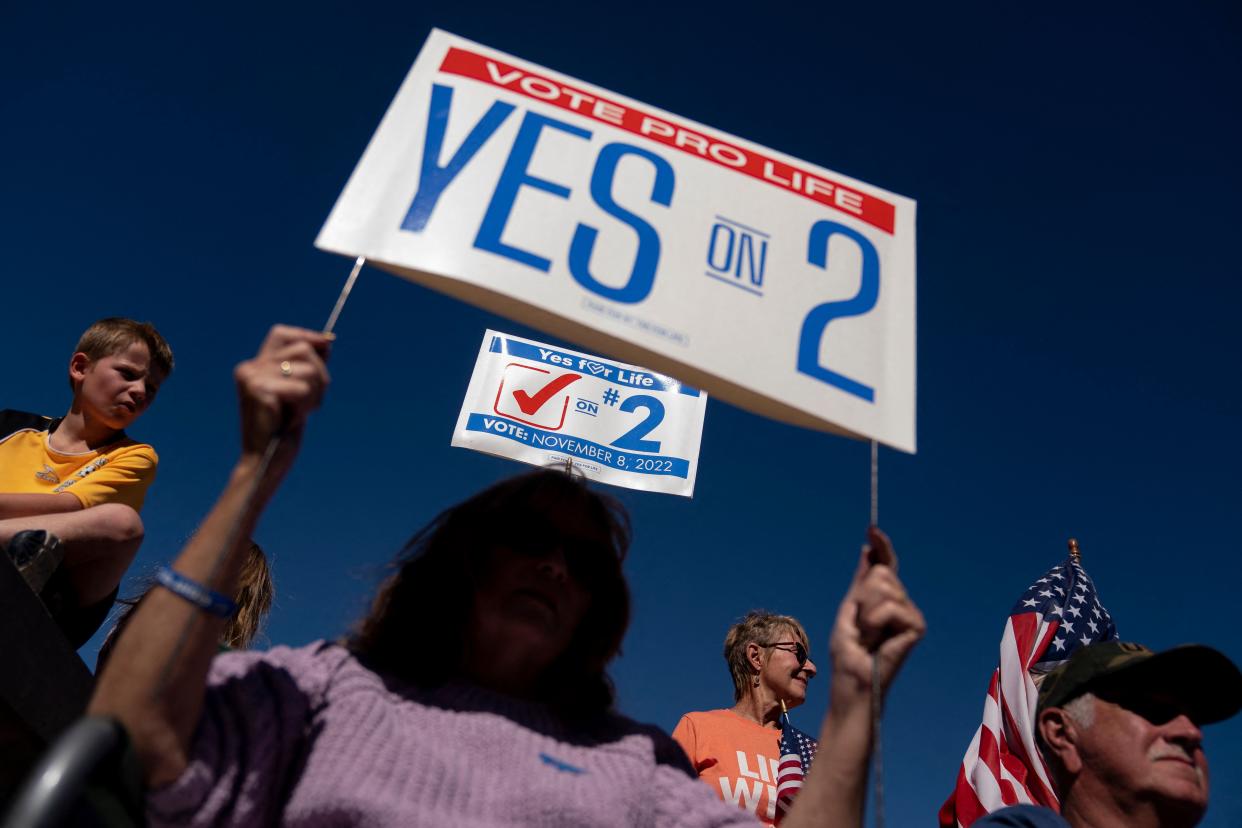 Demonstrators gather in support of an abortion ban, one holding a sign that says: Vote Pro Life, Yes on 2.