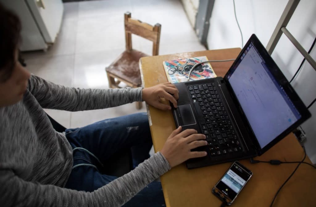 Teenage student Jose Lara studies his daily schoolwork on his laptop at his home in the slum of Catia during the second month of quarantine in the country on April 27, 2020, in Caracas, Venezuela. (Leonardo Fernandez Viloria/Getty Images)