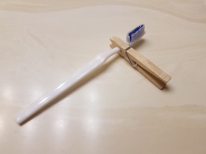 a clothespin on a toothbrush