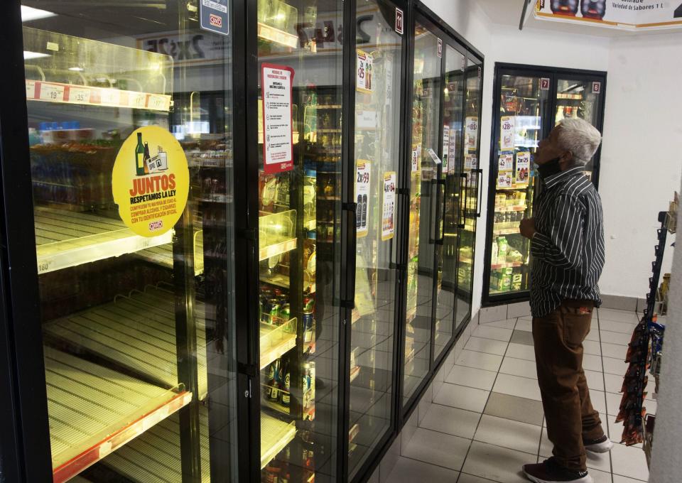 A man looks for a soda drink following the shortage of beer, after the breweries countrywide closed their production due to the coronavirus. Source: AFP