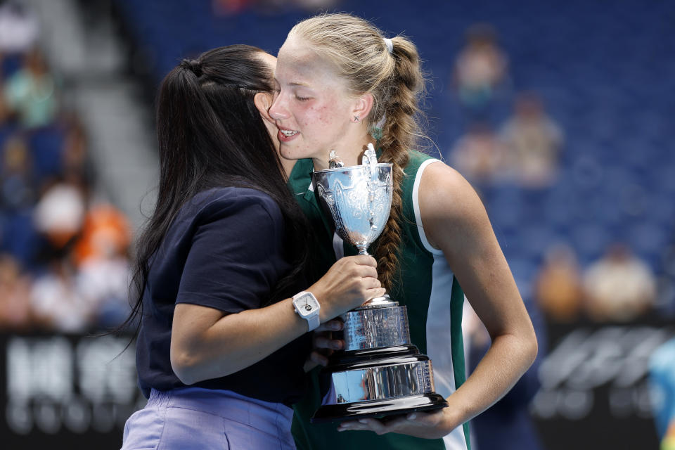 Alina Korneeva (pictured right) receives the championship trophy from Casey Dellacqua (pictured left).