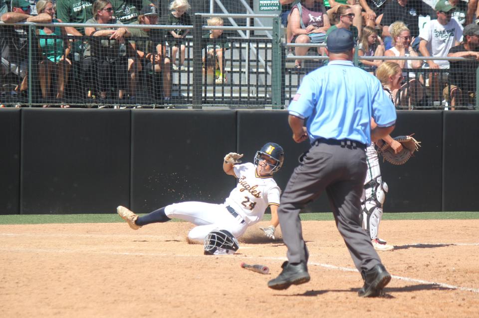 Megan Beemer slides across the plate, scoring for Hudsonville in the Eagles’ 5-0 victory over Lake Orion in the MHSAA Division 1 state softball championship Saturday, June 15, 2024 at Michigan State’s Secchia Stadium in East Lansing.