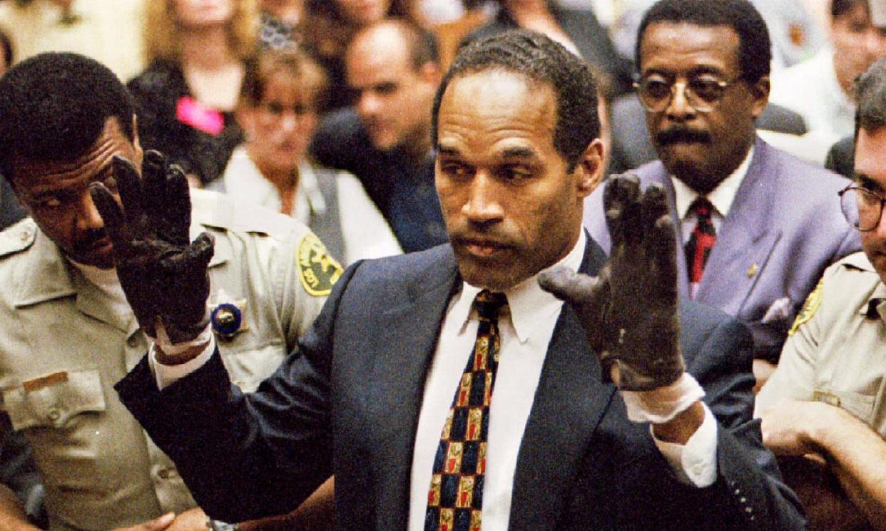 <span>OJ Simpson wears the blood-stained gloves entered into evidence in his murder trial at the request of the prosecutor Christopher Darden in 1995.</span><span>Photograph: Sam Mircovich/Reuters</span>
