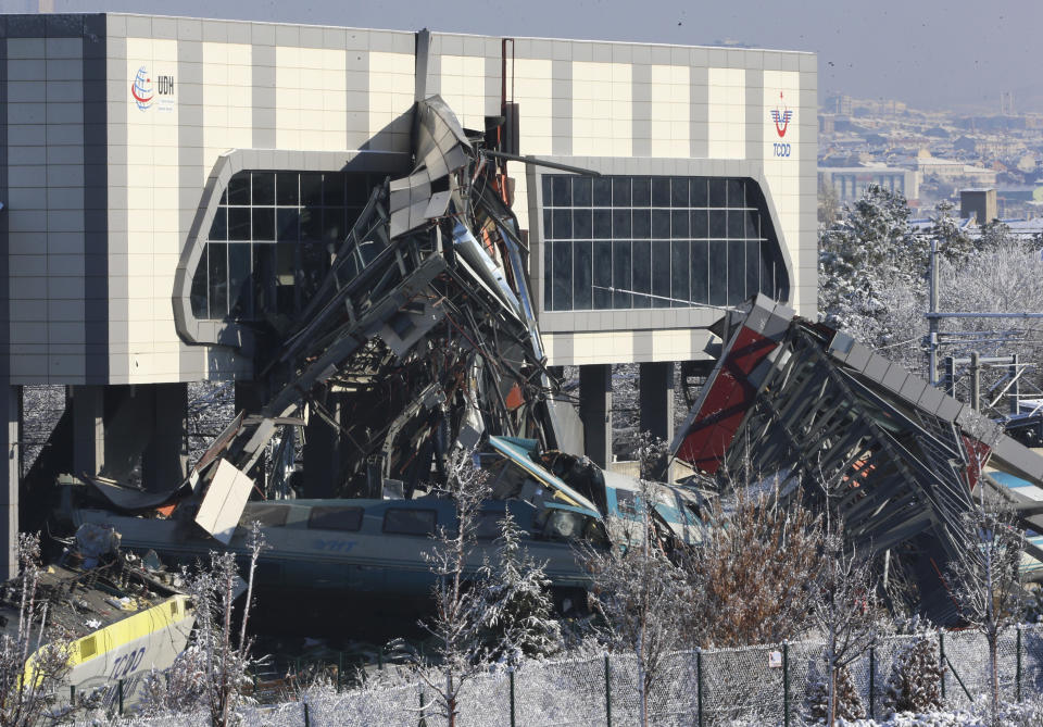 Members of rescue services work at the scene of a train accident in Ankara, Turkey, Thursday, Dec. 13, 2018. A high-speed train hit a railway engine and crashed into a pedestrian overpass at a station in the Turkish capital Ankara on Thursday, killing more than 5 people and injuring more than 40 others, officials and news reports said. (AP Photo/Burhan Ozbilici)