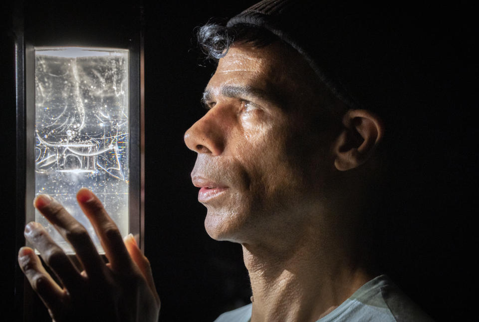 Royal College of Art artist and sculptor Wayne Binitie takes a closer look at his glass sculpture containing air from the year 1765 which is on display at a new immersive exhibition 'Polar Zero' created in collaboration with British Antarctic Survey and global engineering and design firm Arup, at the Glasgow Science Centre to coincide with the Cop26 summit which takes place in Glasgow next month. Picture date: Wednesday September 29, 2020. (Photo by Jane Barlow/PA Images via Getty Images)