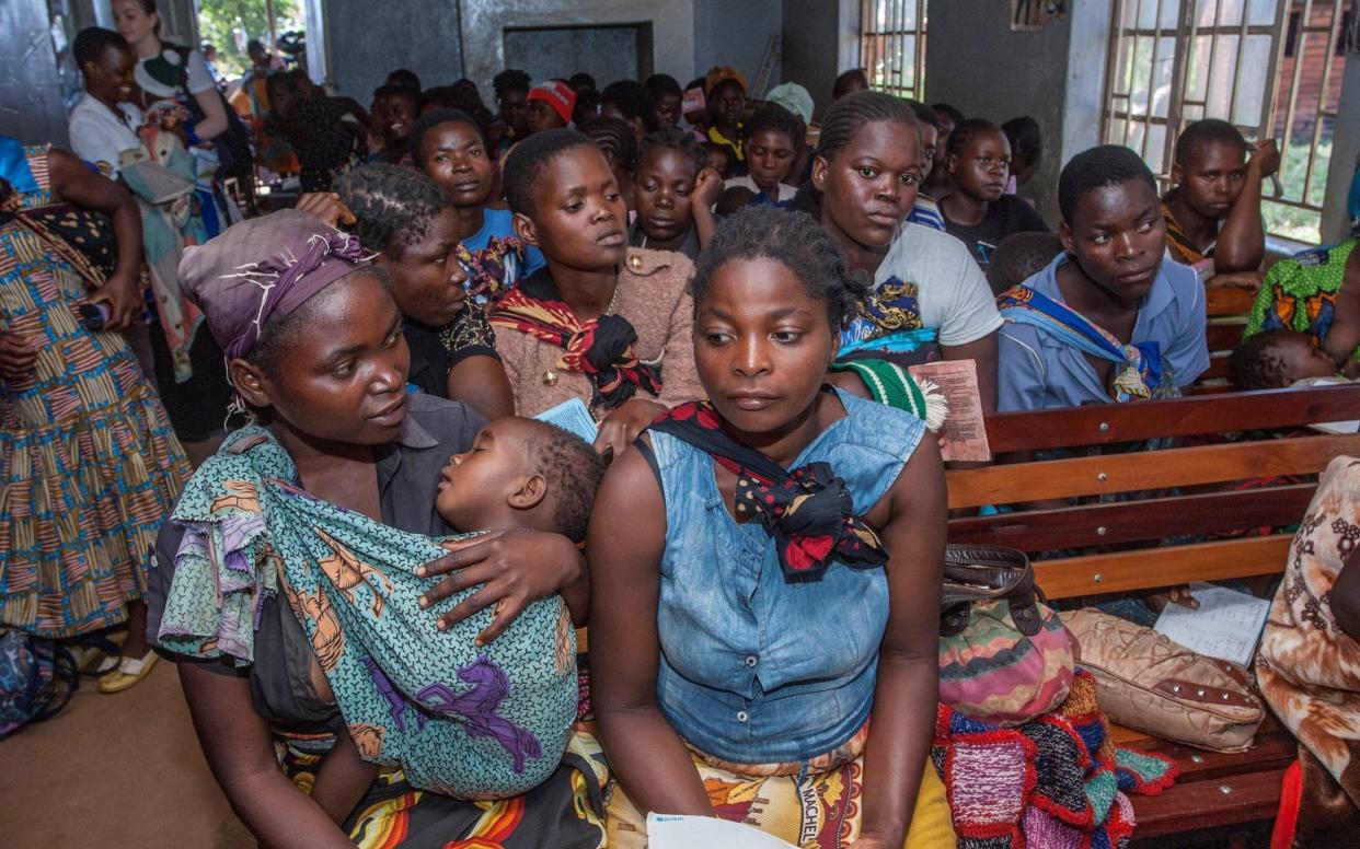 Mothers wait for their children to be given the malaria vaccine at its launch in Malawi - AFP