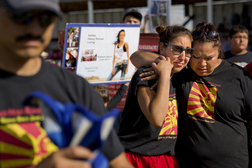 FILE - In this July 14, 2018 file photo, Jenna Loring, left, the aunt of Ashley HeavyRunner Loring, cries with her cousin, Lissa Loring, during a traditional blanket dance before the crowd at the North American Indian Days celebration on the Blackfeet Indian Reservation in Browning, Mont. A study released by a Native American non-profit says numerous police departments in cities nationwide are not adequately identifying or reporting cases of missing and murdered indigenous women. (AP Photo/David Goldman, File)