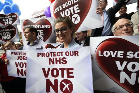 'No' supporters hold signs after a 'No' campaign rally in Glasgow, Scotland, in this September 17, 2014 file photo. REUTERS/Dylan Martinez/Files