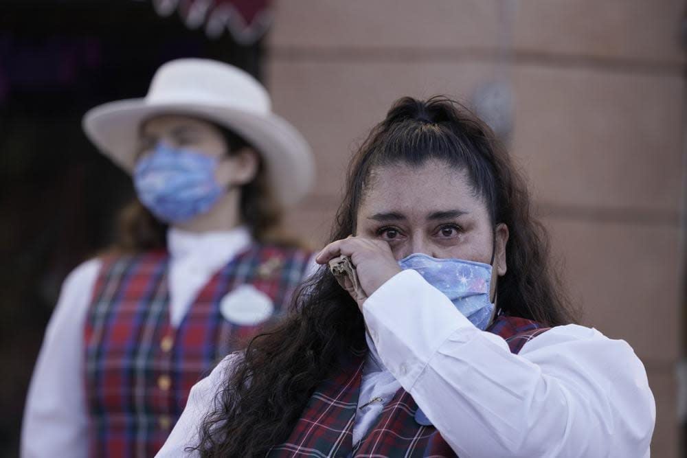 Employee Norali (last names not given), sheds a tear as they prepare to open the gates at Disneyland in Anaheim, Calif., Friday, April 30, 2021. (AP Photo/Jae Hong)