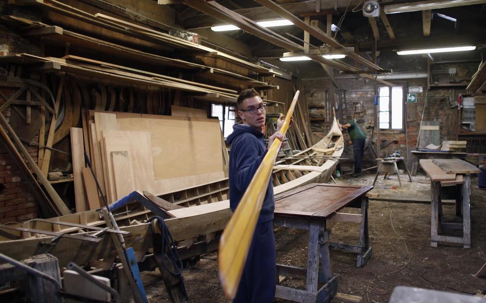 A gondolier holds an oar of his gondola at the San Trovaso boatyard known as a