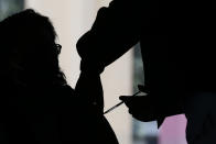 A medical worker injects a woman with a dose of the Russian COVID-19 vaccine Sputnik V at the Palacio de los Deportes, in the Iztacalco borough of Mexico City, Wednesday, Feb. 24, 2021. (AP Photo/Rebecca Blackwell)