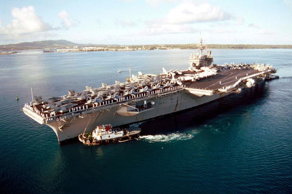 Sailors man the rails as the aircraft carrier USS Kitty Hawk (CV 63) enters into Apra Harbor, Guam, April 20, 2001