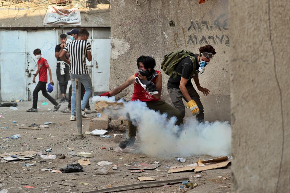 Riot police fire tear gas during clashes with anti-Government protesters at Khilani Square in Baghdad, Iraq, Thursday, Nov. 14, 2019. (AP Photo/Hadi Mizban)