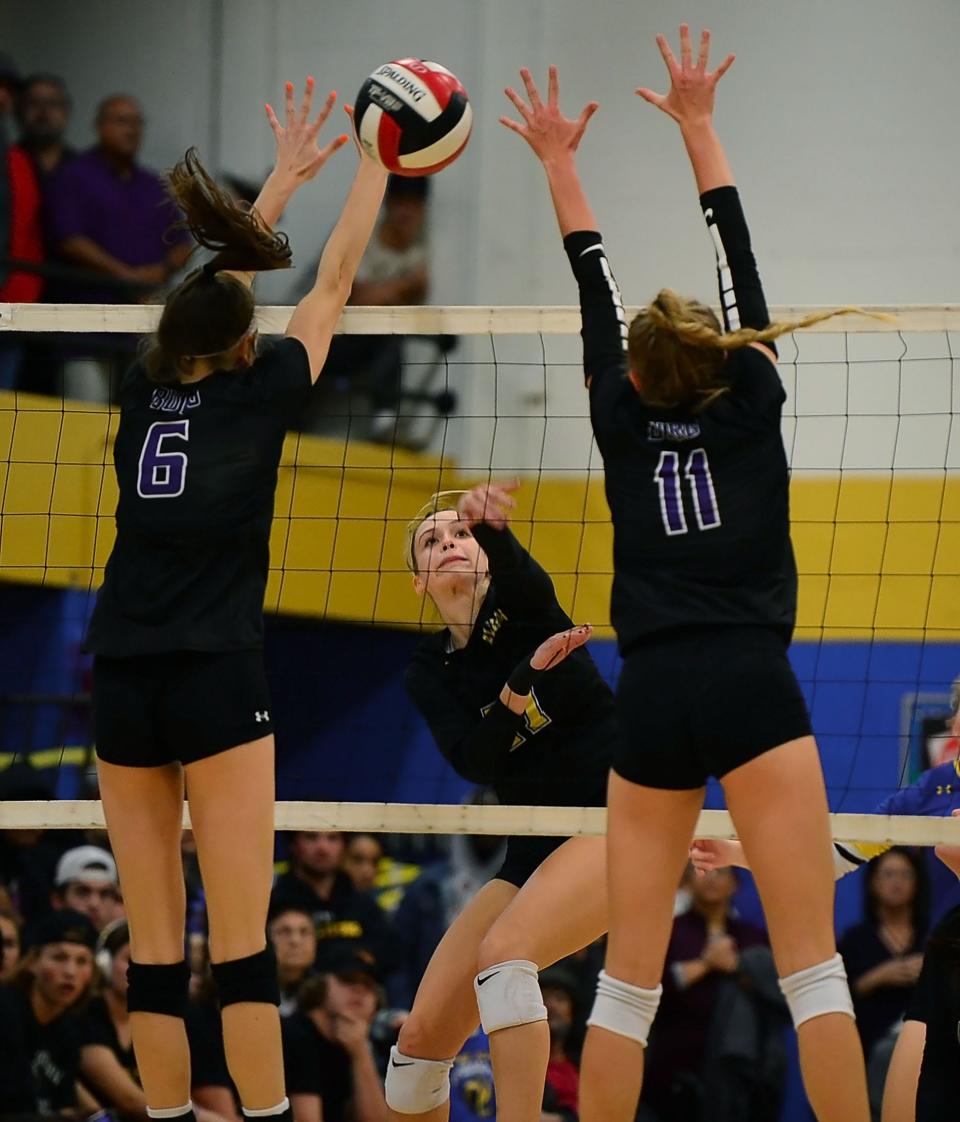 Clear Spring's Addison Zeigler, middle, sends a kill attempt past the reach of Smithsburg's Kylie Snyder, left, and Kassidy Meadows in the third set of the 1A West Region II final at Clear Spring.