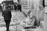 <p>A woman sits in a chair on Rue des Saints Pères, near l’École de Médecine on May 11, 1968, a day after student clashes with police in the Latin Quarter of Paris. (Photo: Gökşin Sipahioğlu/SIPA) </p>