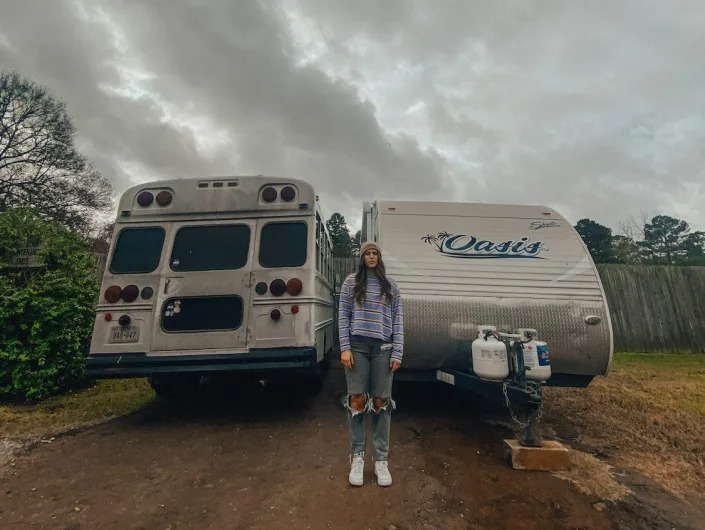 Heather Mclarry stands in front of her old school bus and new camper.