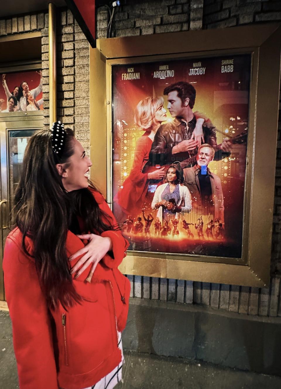 Amber Ardolino checks out her name and photo on the marquee of the Broadway theater where she's co-starring in "A Beautiful Noise," the Neil Diamond musical.