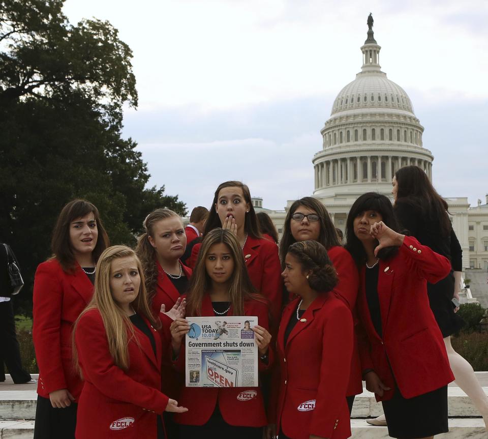 Members of the Family, Career and Community Leadership of America group, pose in front of the U.S. Capitol in Washington on day one of the government shutdown October 1, 2013. The U.S. government began a partial shutdown on Tuesday for the first time in 17 years, potentially putting up to 1 million workers on unpaid leave, closing national parks and stalling medical research projects. The FCCLA group was scheduled to meet with members of the Congress on Tuesday. REUTERS/Gary Cameron (UNITED STATES - Tags: POLITICS BUSINESS)