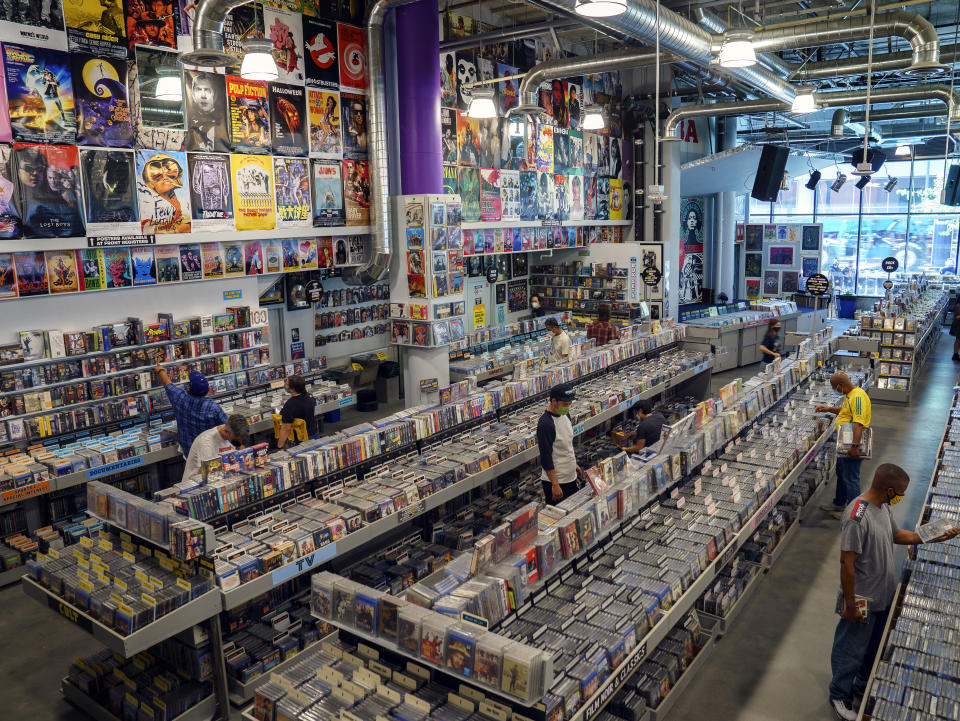 Customers shop at the newly reopened Amoeba Music, the World's largest independent record store, in Los Angeles Friday, April 2, 2021. Most of California's 58 counties are in the red tier, but big population centers like San Francisco, Santa Clara County and Los Angeles County are in the less restrictive orange tier. Just two counties are in the lowest yellow tier. California on Friday cleared the way for people to attend indoor concerts, theater performances and NBA games for the first time in more than a year as the rate of people testing positive for the coronavirus in the state nears a record low. (AP Photo/Damian Dovarganes)