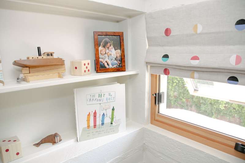 built in shelves in white kids' room by the window