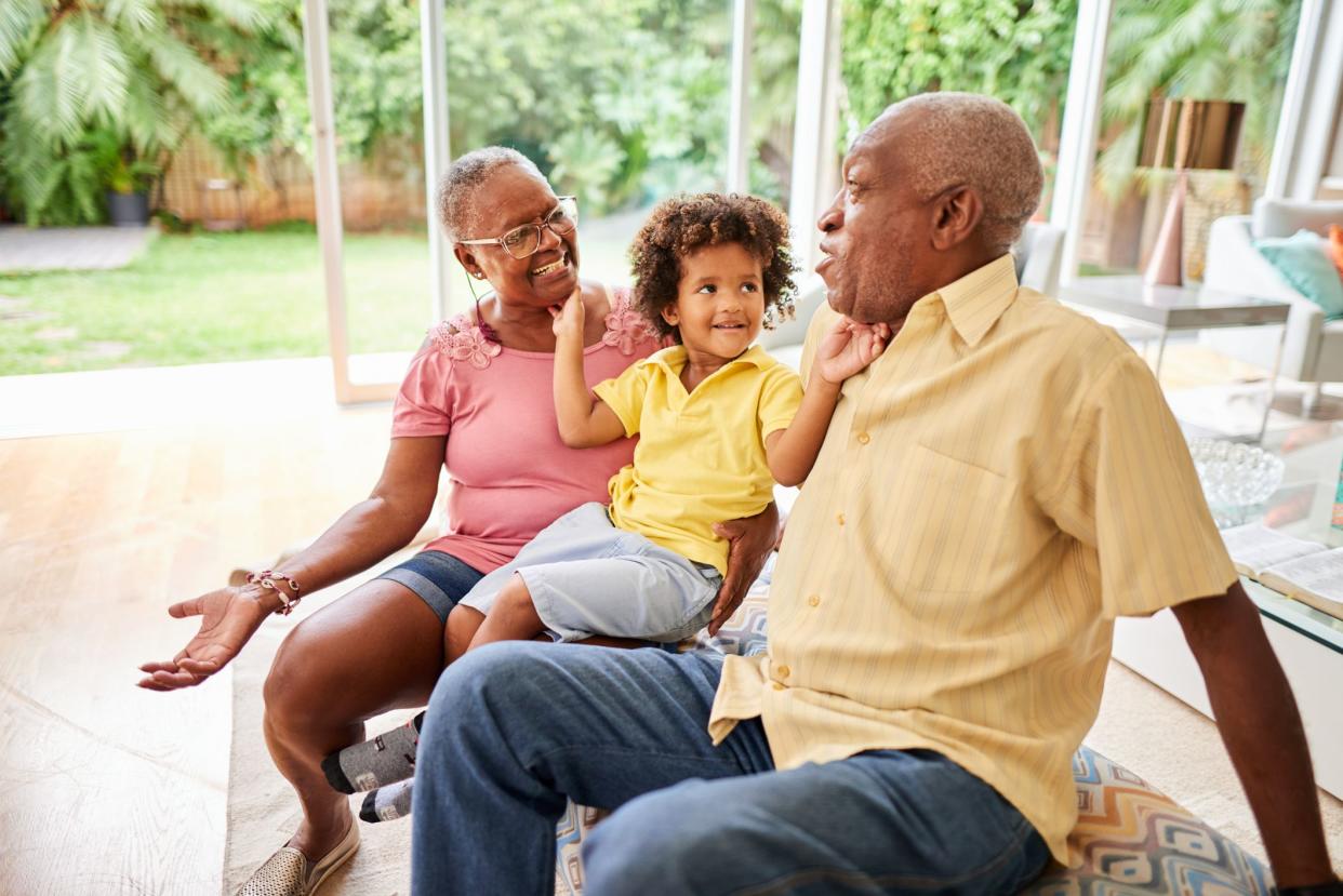 Shot of a little boy sitting with his grandparents at home