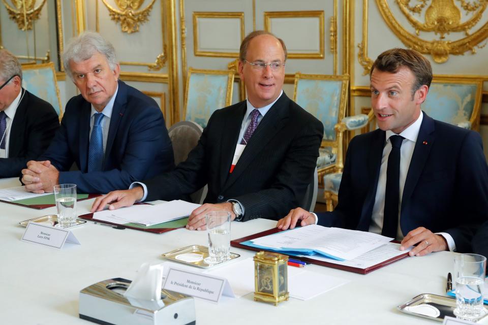 Amundi CEO Yves Perrier (L), chairman and CEO of BlackRock, Larry Fink (C) sit alongside French President Emmanuel Macron as they attend a meeting between the French President and representatives of investment funds and sovereign wealth funds to fight climate change at the Elysee Palace in Paris on July 10, 2019. (Photo by Michel Euler / POOL / AFP)        (Photo credit should read MICHEL EULER/AFP via Getty Images)