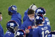 New York Giants quarterback Daniel Jones, center, talks to quarterback Colt McCoy (12) during the first half of an NFL football game against the Cleveland Browns, Sunday, Dec. 20, 2020, in East Rutherford, N.J. (AP Photo/Corey Sipkin)