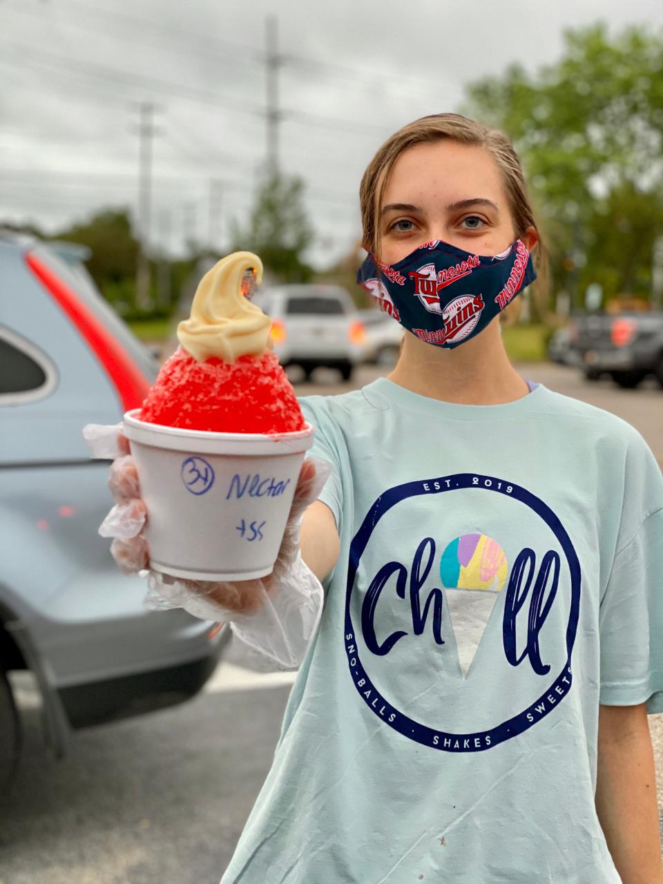 Chill Frozen Treats & Sweets employee Taryn Miskowiec delivers a sno-ball to a car on May 26, 2020.