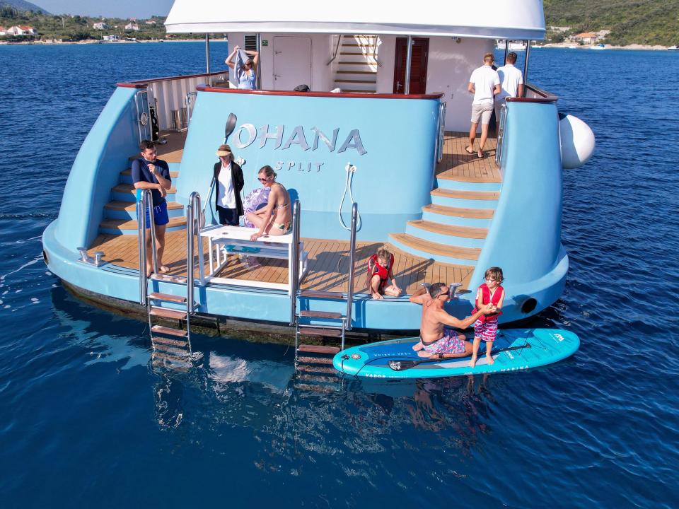 A view of the swimming platform with people on a paddle board.