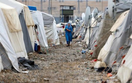 A Syrian refugee woman walks between tents in Nizip refugee camp, near the Turkish-Syrian border in Gaziantep province, Turkey, November 30, 2016. REUTERS/Umit Bektas