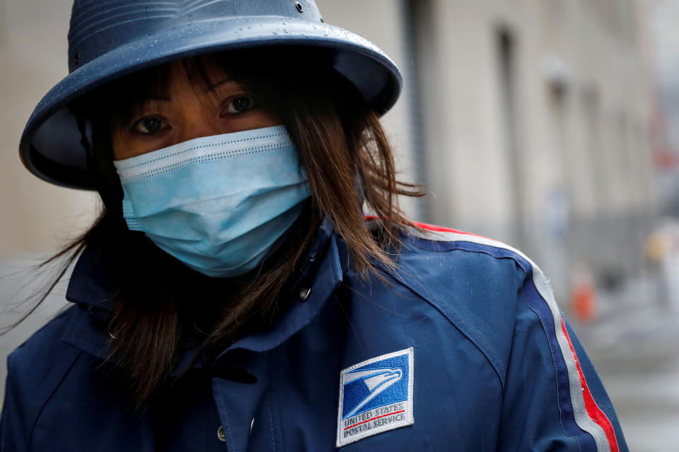 A USPS employee works in the rain in Manhattan during the outbreak of the coronavirus in New York City on April 13, 2020.   (Photo: REUTERS/Andrew Kelly)