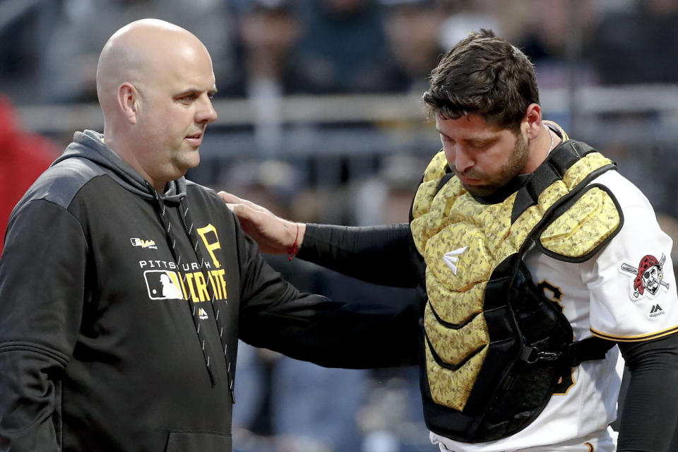 Pittsburgh Pirates trainer Bryan Housand, left, checks on catcher Francisco Cervelli during the fifth inning of the team's baseball game against the Colorado Rockies, Tuesday, May 21, 2019, in Pittsburgh. Cervelli left the game in the following inning. (AP Photo/Keith Srakocic)