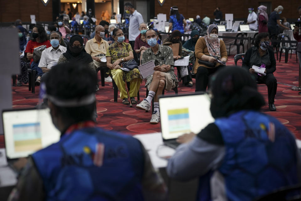 People wait to receive the Pfizer vaccine for the coronavirus at a vaccination center in Subang Jaya, Malaysia, Tuesday, April 27, 2021. (AP Photo/Vincent Thian)