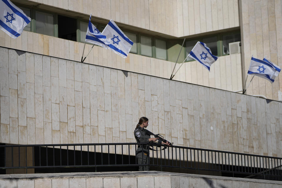 An Israeli border police officer takes position next to the scene of a car ramming attack, in Jerusalem, Monday, April 24, 2023. Israeli Prime Minister Benjamin Netanyahu says multiple people have been attacked and wounded near a popular market in Jerusalem as Israel was set to mark its Memorial Day for fallen soldiers. Netanyahu spoke Monday moments after medics reported a suspected attack injured five people near the bustling, open-air Mahane Yehuda market. (AP Photo/Ohad Zwigenberg)