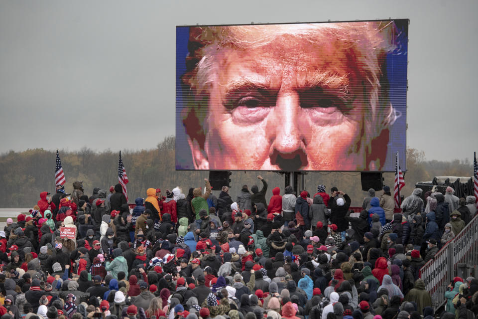 FILE - In this Oct. 27, 2020, file photo, supporters of President Donald Trump watch a video during a campaign event in Lansing, Mich. (Nicole Hester/Mlive.com/Ann Arbor News via AP, File)