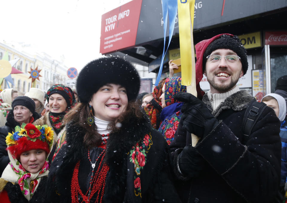 People react after the service marking Orthodox Christmas and celebrating the independence of the Ukrainian Orthodox Church out of the St. Sophia Cathedral in Kiev, Ukraine, Monday, Jan. 7, 2019. (AP Photo/Efrem Lukatsky)