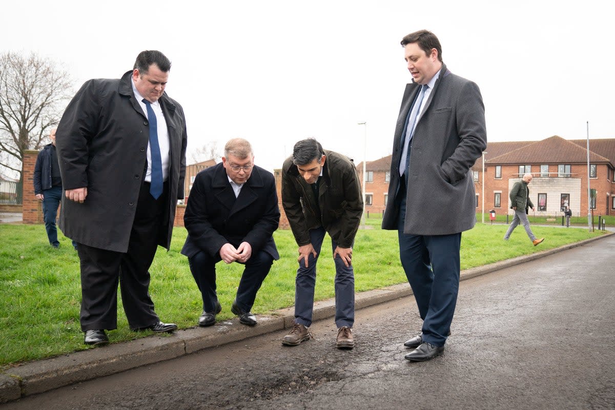 ‘A plague on our roads’: Rishi Sunak inspects a pothole in Darlington, County Durham (PA)