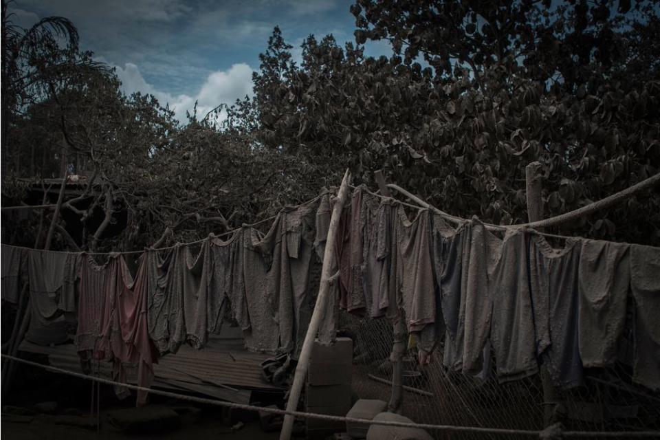 An ash-covered clothesline hangs outside a home in San Miguel Los Lotes on June 5.