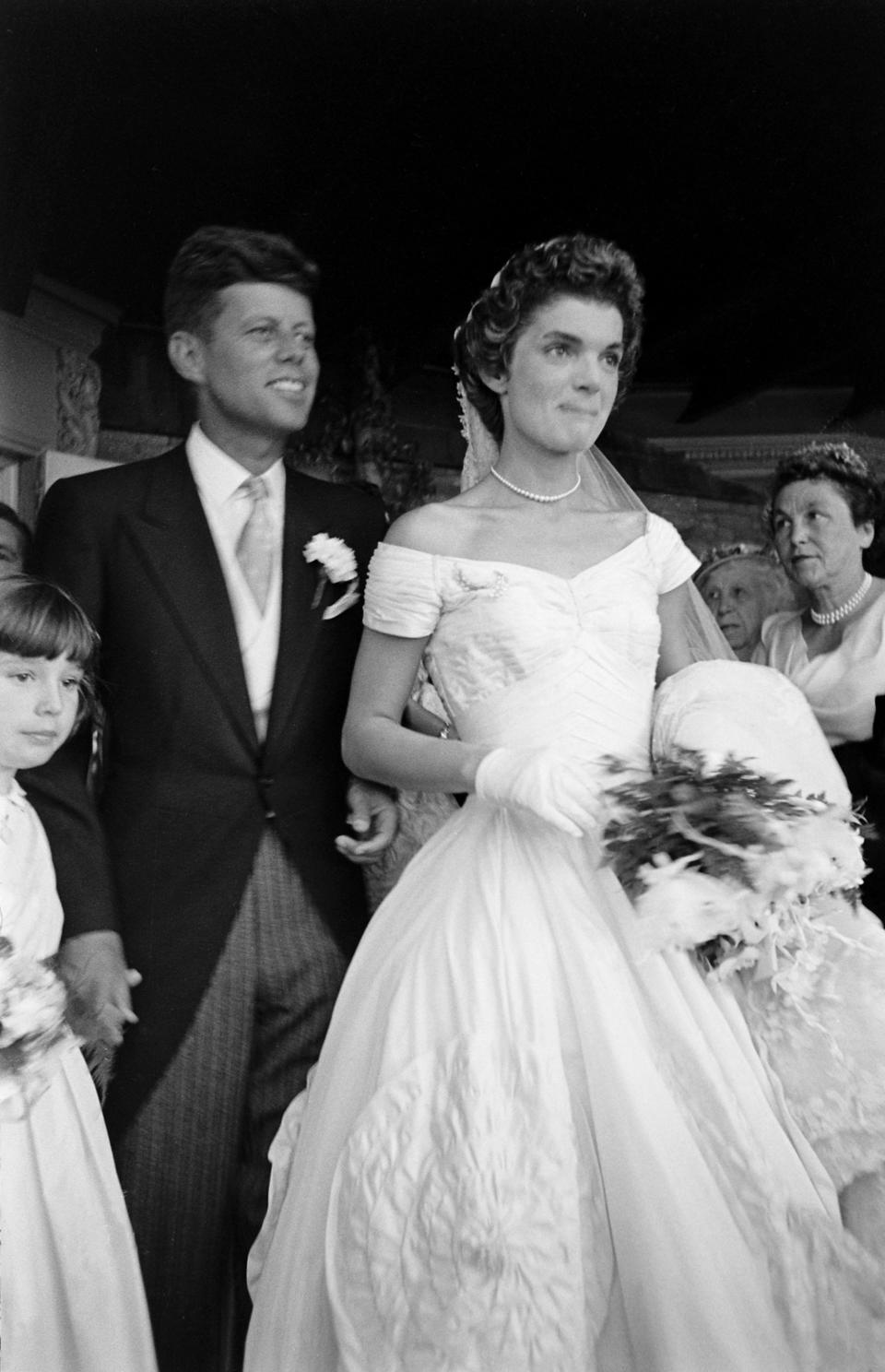 Future US President John F Kennedy (1917 - 1963) and Jacqueline Kennedy (1929 - 1994) (in a Battenburg wedding dress) stand in front of St Mary's Church after their wedding ceremony, Newport, Rhode Island, September 12, 1953. (Photo by Lisa Larsen/Time & Life Pictures/Getty Images)