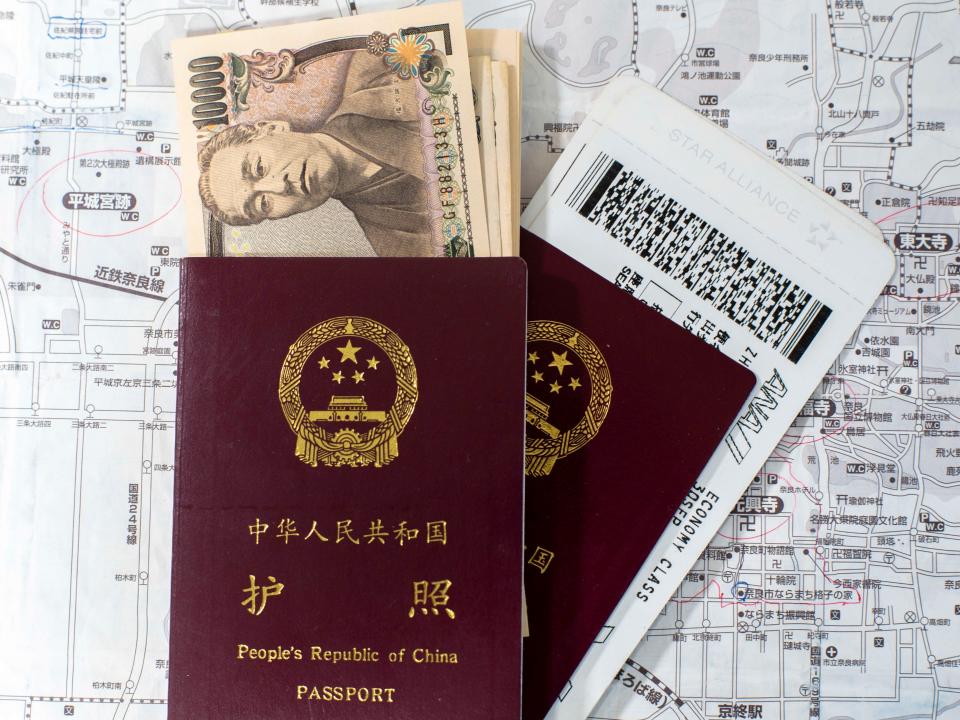 Passeport chinois, yen japonais et billets d'avion, arrangés pour la photographie.